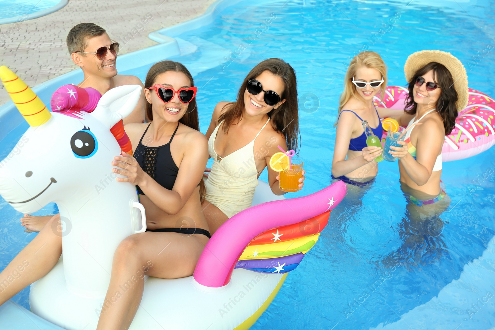 Photo of Group of happy people enjoying fun pool party