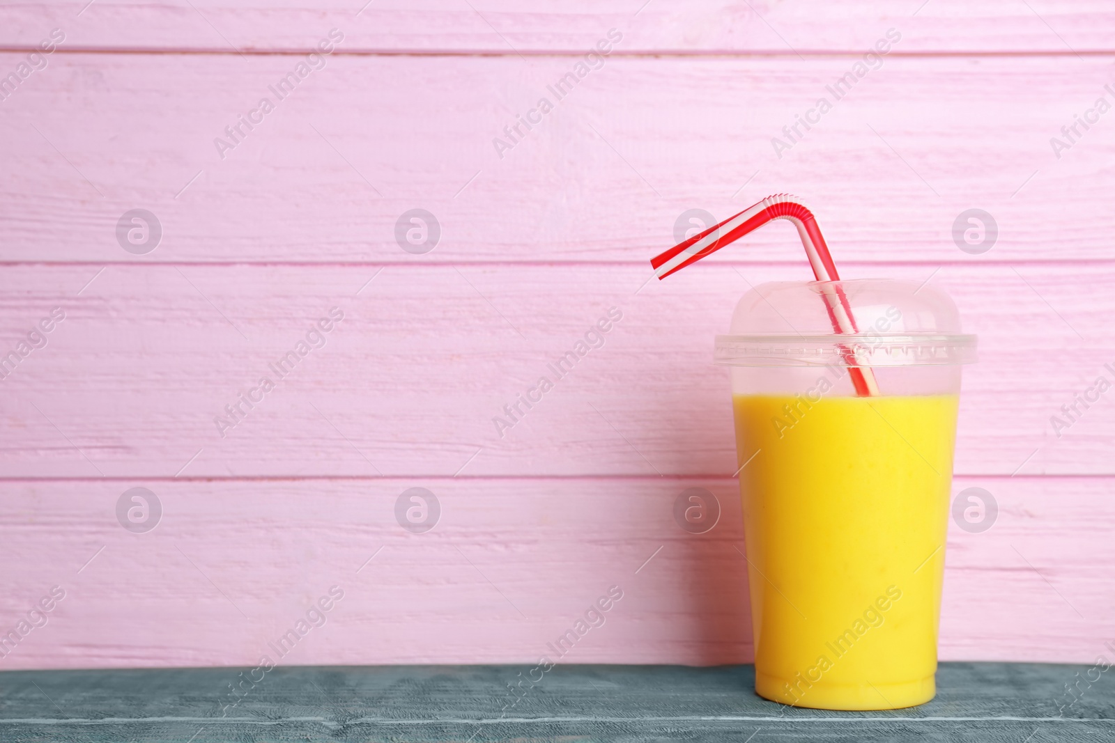 Photo of Plastic cup with delicious detox smoothie on table