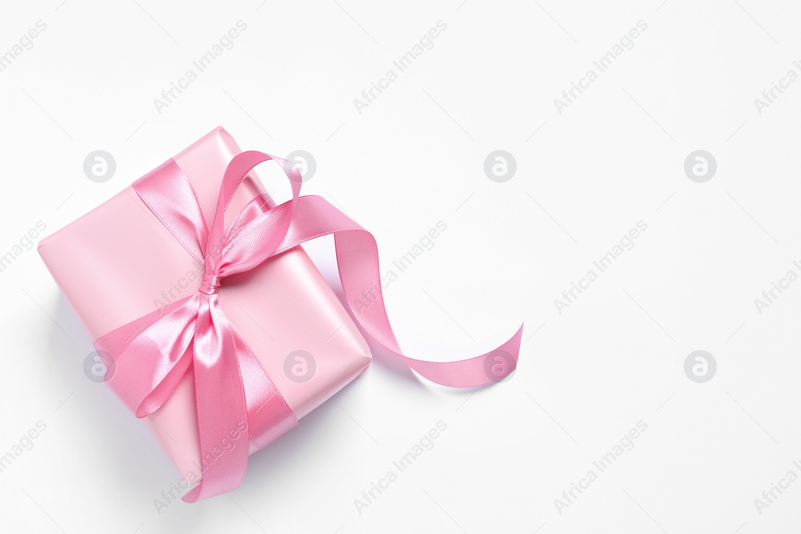 Photo of Beautiful gift box with pink bow on white background, top view. Space for text