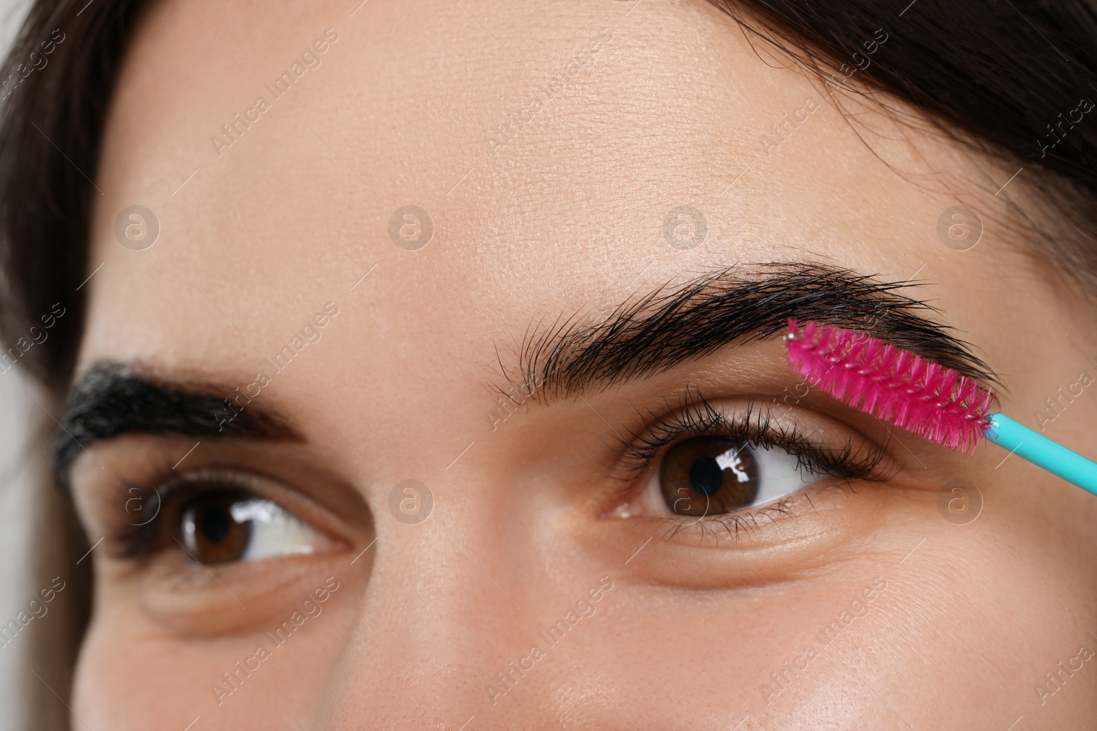 Photo of Brushing woman's eyebrows after tinting, closeup view