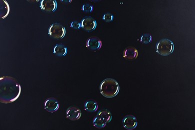 Photo of Beautiful transparent soap bubbles on dark background