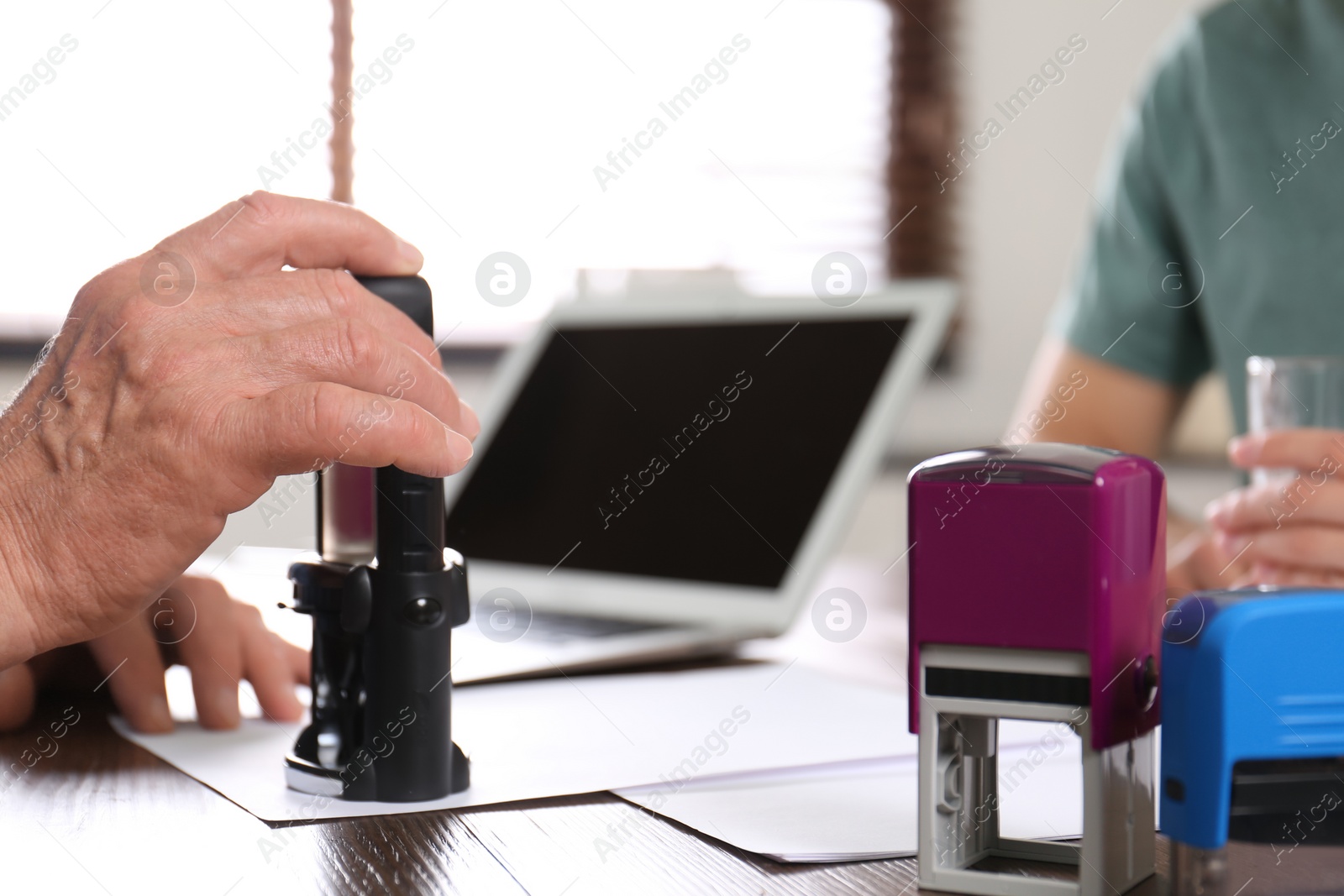 Photo of Senior notary working with clients in office, closeup