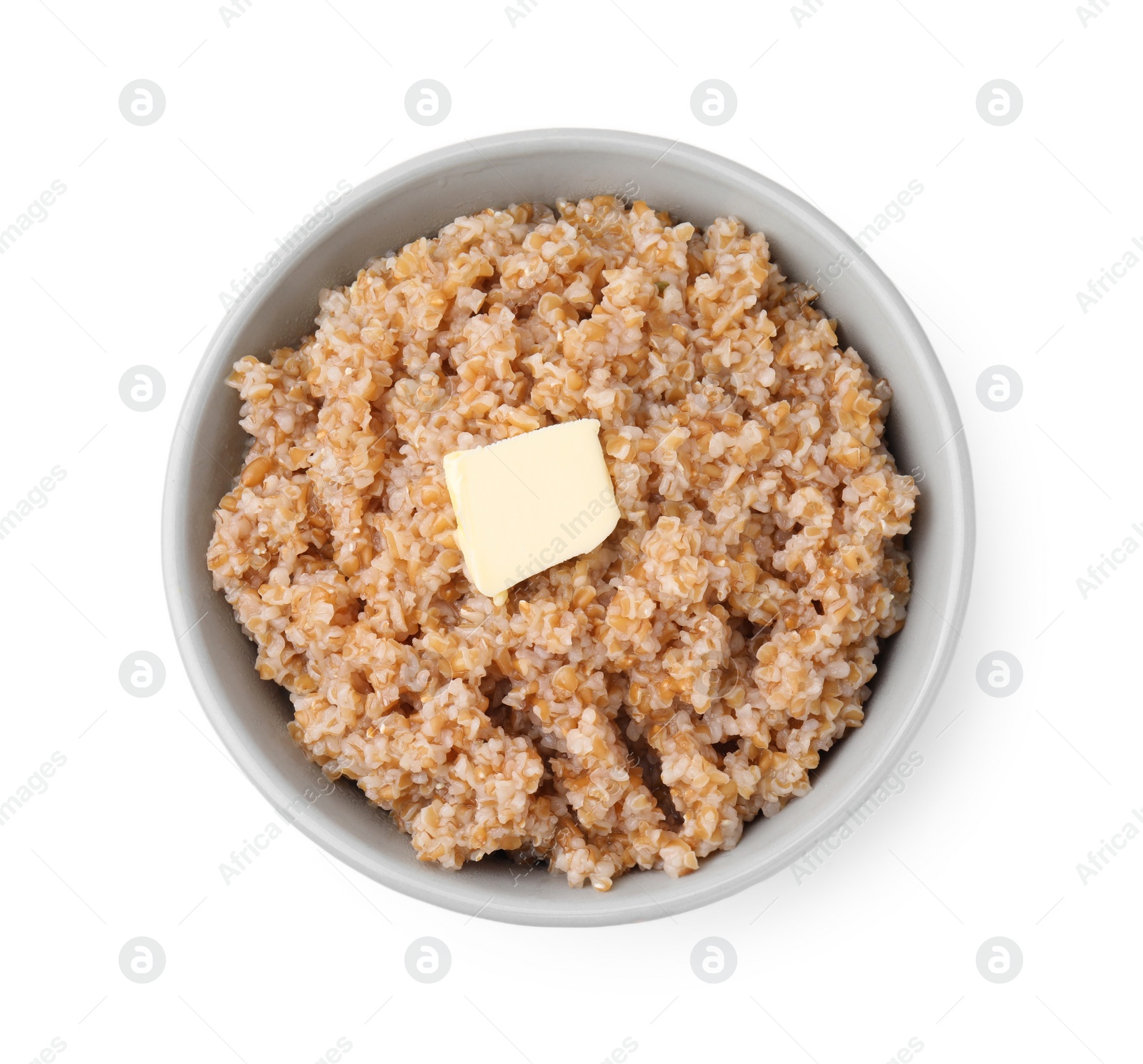 Photo of Tasty wheat porridge with butter in bowl isolated on white, top view