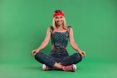 Portrait of happy hippie woman on green background