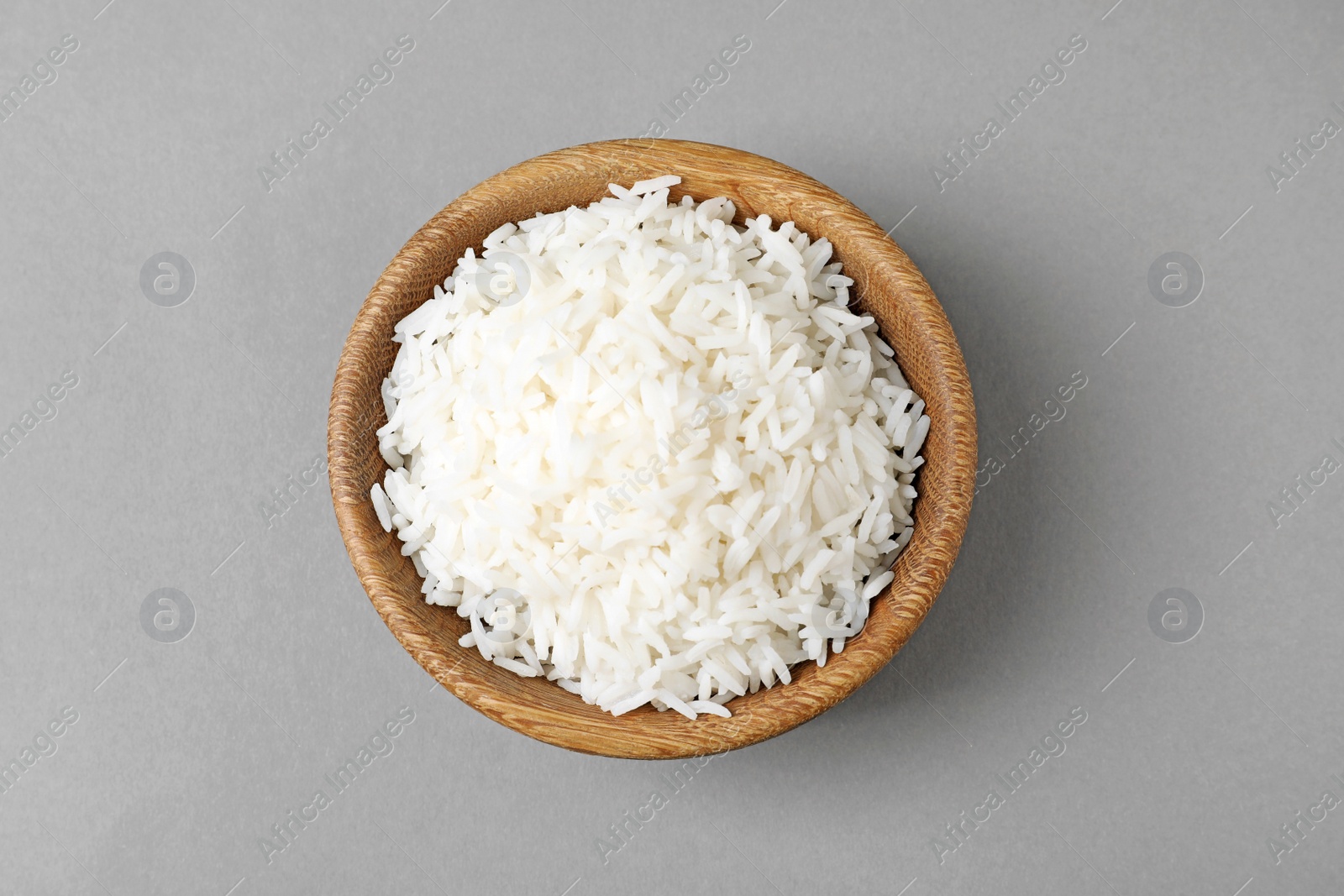 Photo of Bowl of tasty cooked rice on grey background, top view
