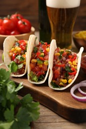 Photo of Tasty tacos with vegetables on wooden table, closeup