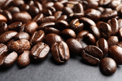 Roasted coffee beans on grey background, closeup