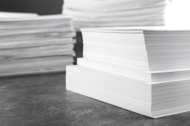 Photo of Stack of blank white paper on marble table, closeup. Space for text