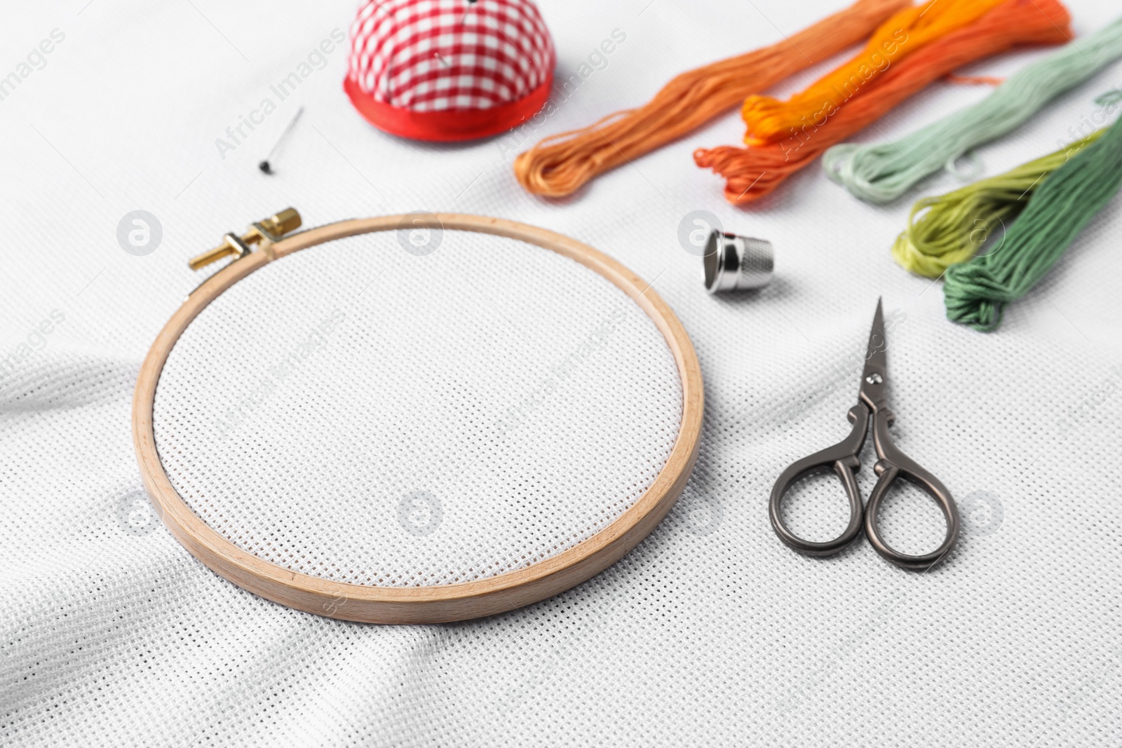 Photo of Embroidery hoop with white fabric and other accessories