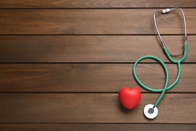 Photo of Stethoscope, red decorative heart and space for text on wooden background, flat lay. Cardiology concept