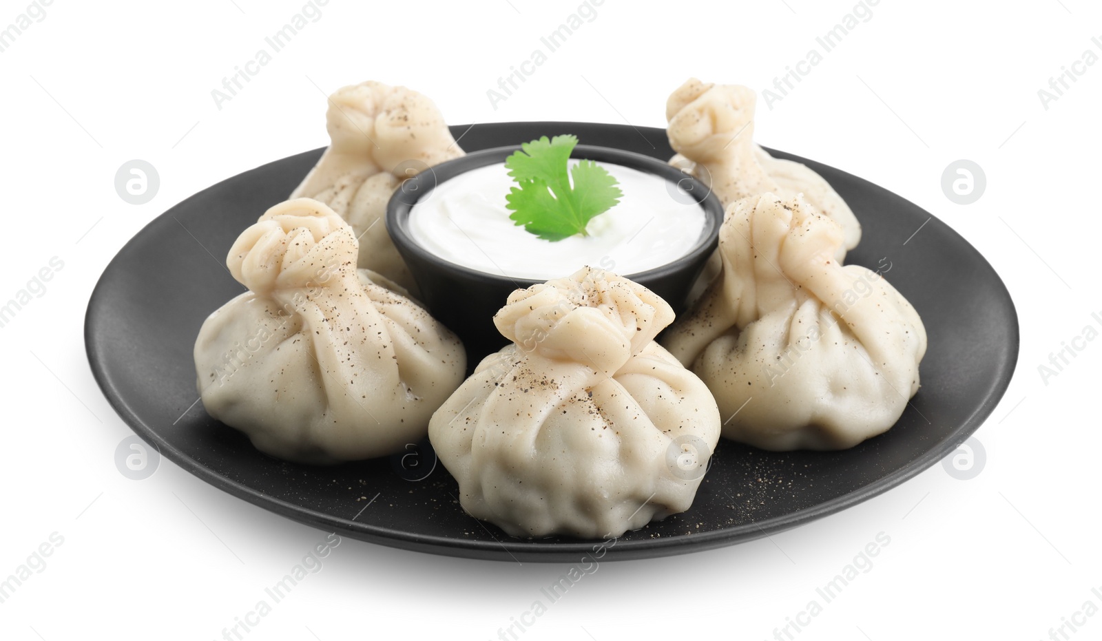 Photo of Tasty khinkali (dumplings) with sauce and spices isolated on white. Georgian cuisine