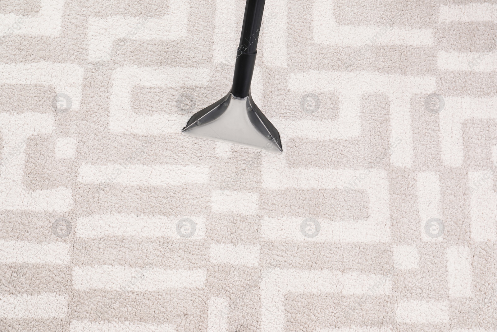 Photo of Removing dirt from carpet with vacuum cleaner indoors, closeup. Space for text