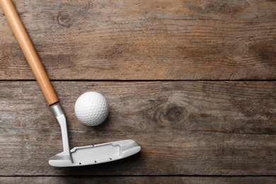 Photo of Golf club and ball on wooden background, flat lay with space for text