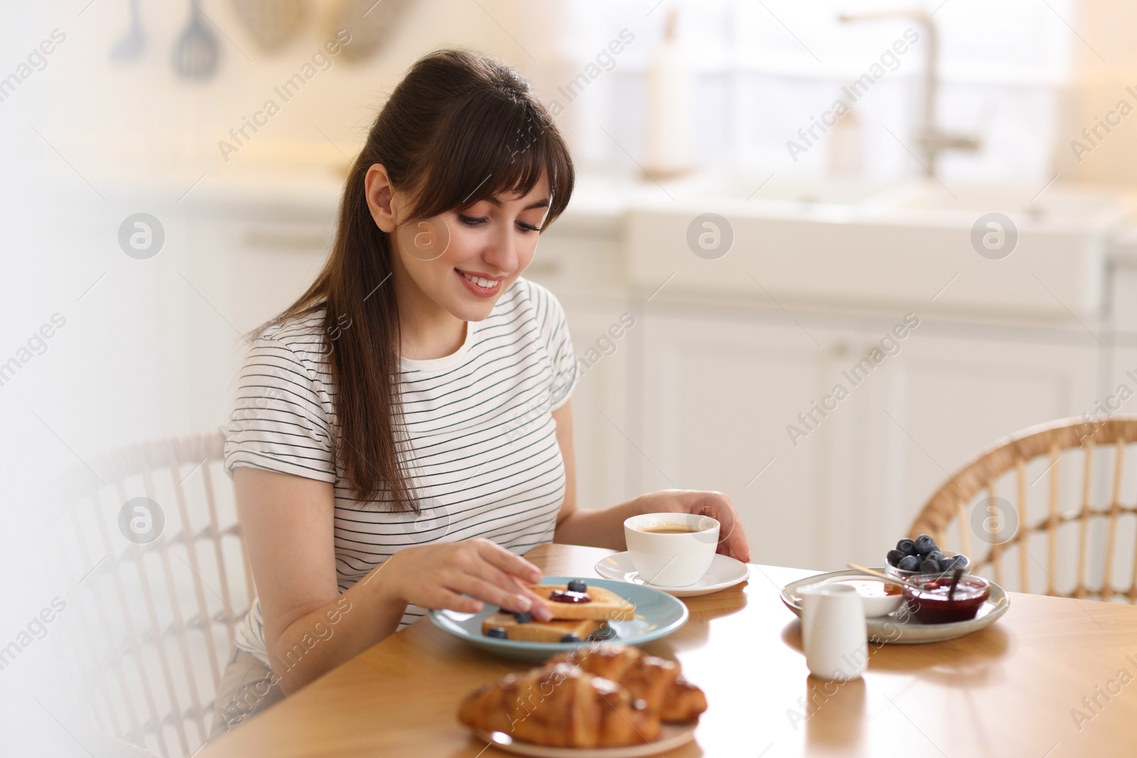 Photo of Smiling woman eating tasty breakfast at table indoors