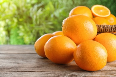 Photo of Fresh juicy oranges on wooden table. Space for text