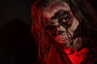 Photo of Scary zombie on dark background, closeup. Halloween monster