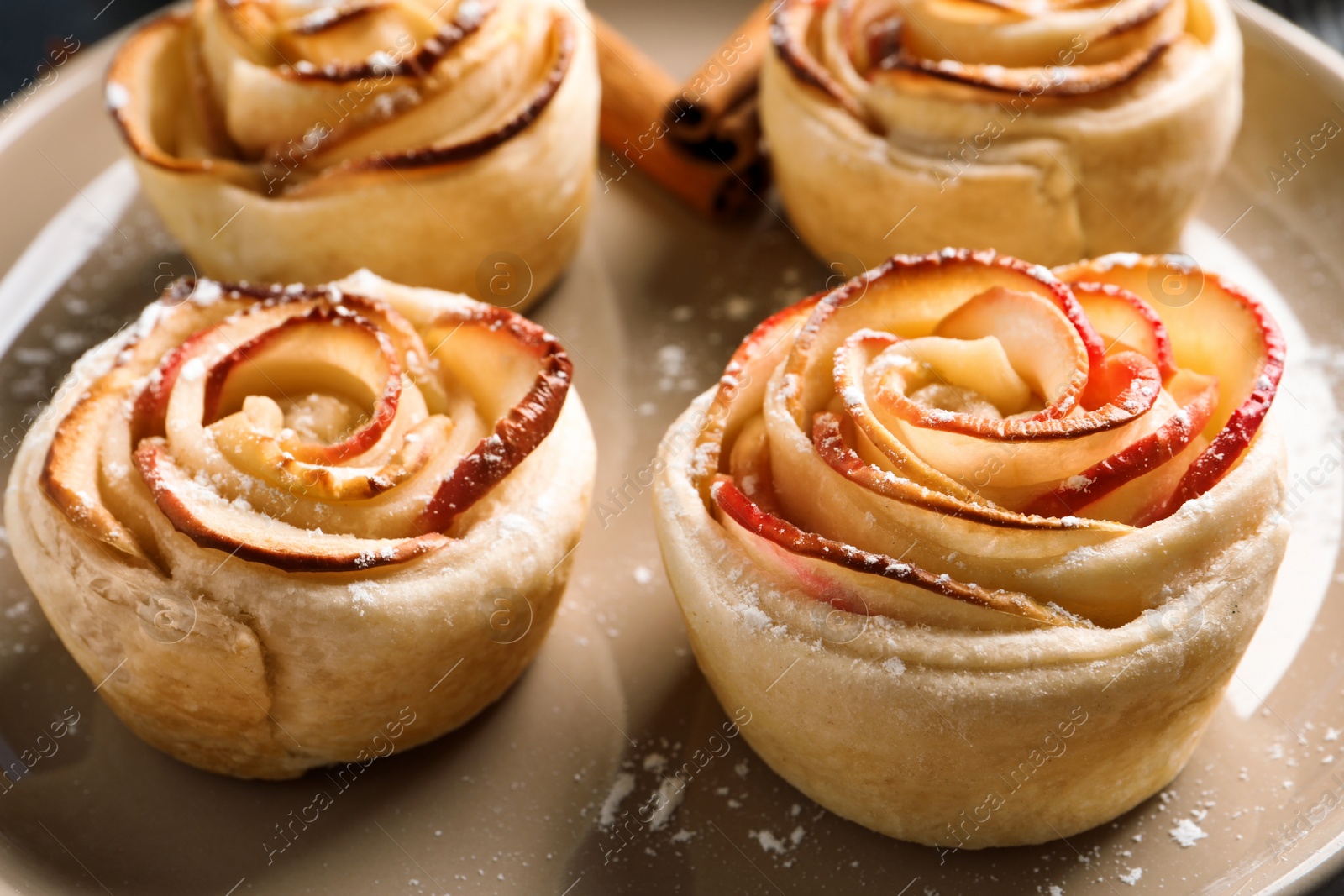 Photo of Freshly baked apple roses on plate, closeup. Beautiful dessert
