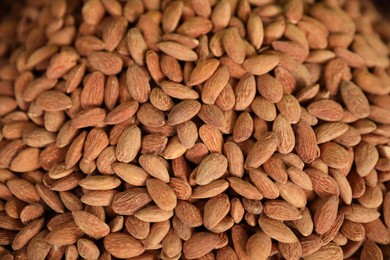 Photo of Heap of delicious almonds as background, top view