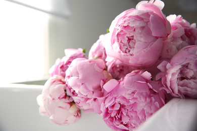 Photo of Bouquet of beautiful pink peonies in kitchen sink, closeup