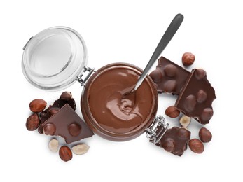 Photo of Chocolate pieces, jar with sweet paste and hazelnuts on white background, top view