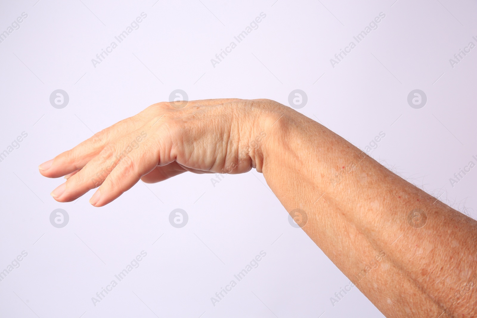 Photo of Closeup view of older woman's hand on white background