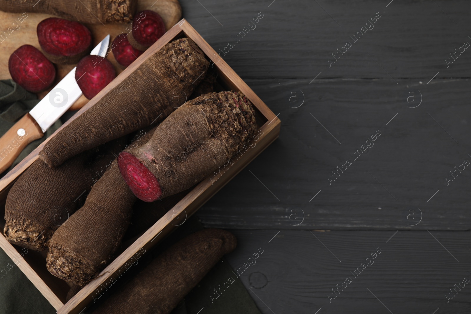 Photo of Red beets and knife on gray wooden table, flat lay. Space for text