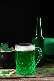 Photo of St. Patrick's day party. Green beer, leprechaun hat, pot of gold and decorative clover leaves on wooden table