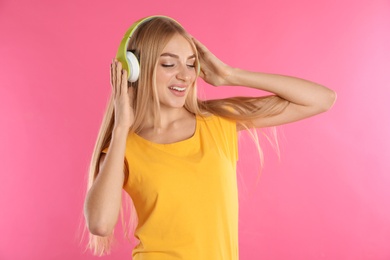 Photo of Beautiful young woman listening to music with headphones on color background