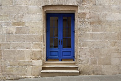 Photo of View of building with blue wooden door. Exterior design