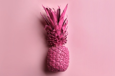 Photo of Painted pineapple on pink background, top view. Creative concept