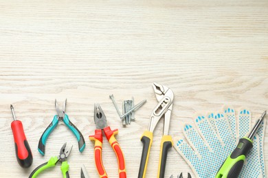 Photo of Different pliers, screwdrivers and other repair tools on wooden table, flat lay. Space for text
