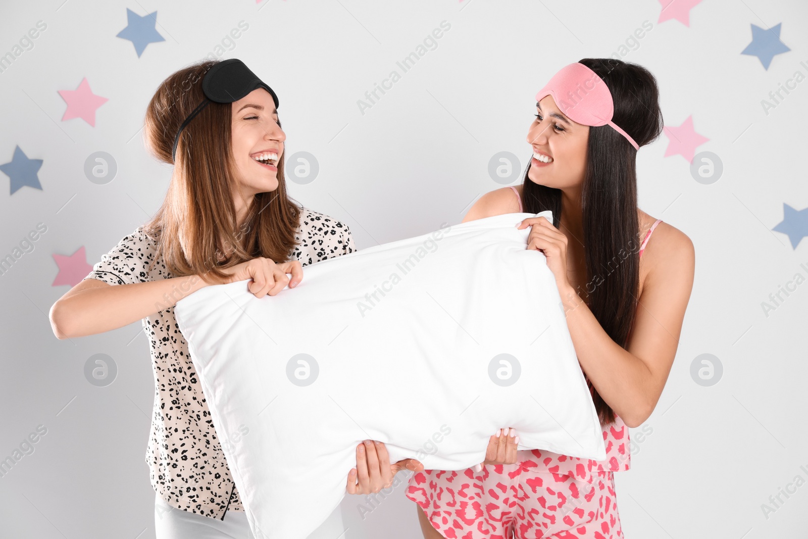 Photo of Beautiful women with pillow on light grey background. Bedtime