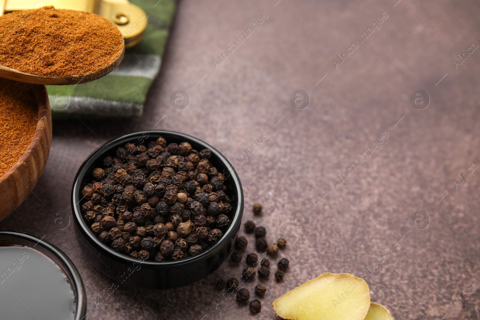 Photo of Aromatic peppercorns and different fresh ingredients for marinade on brown table. Space for text