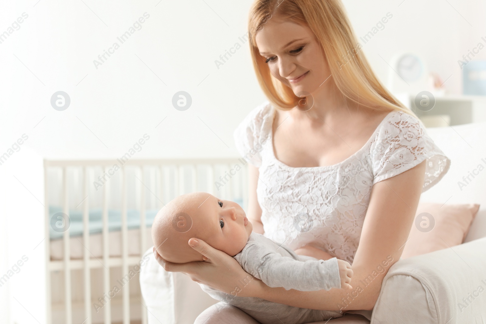 Photo of Happy mother with her baby sitting in armchair at home