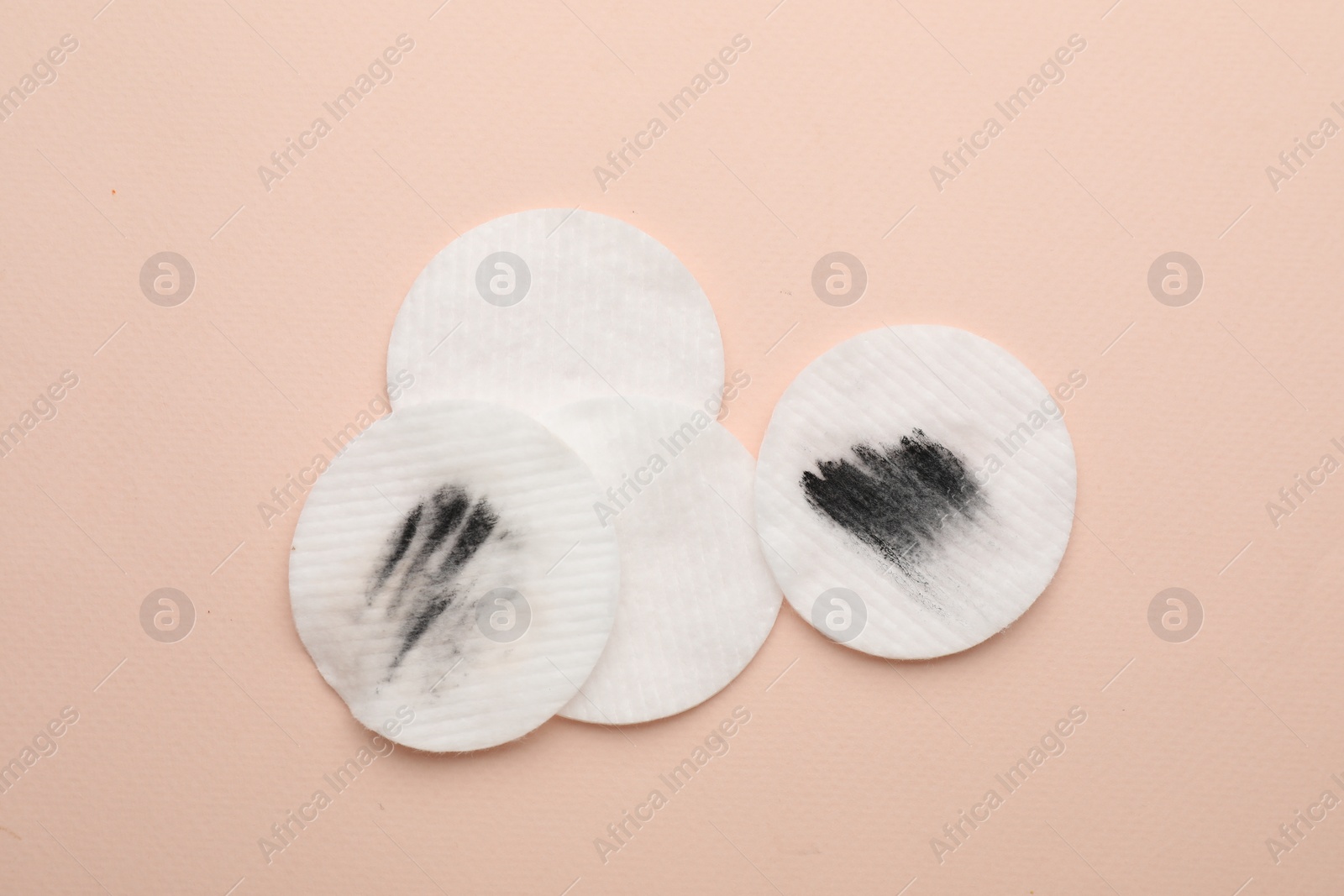 Photo of Clean and dirty cotton pads after removing makeup on beige background, flat lay