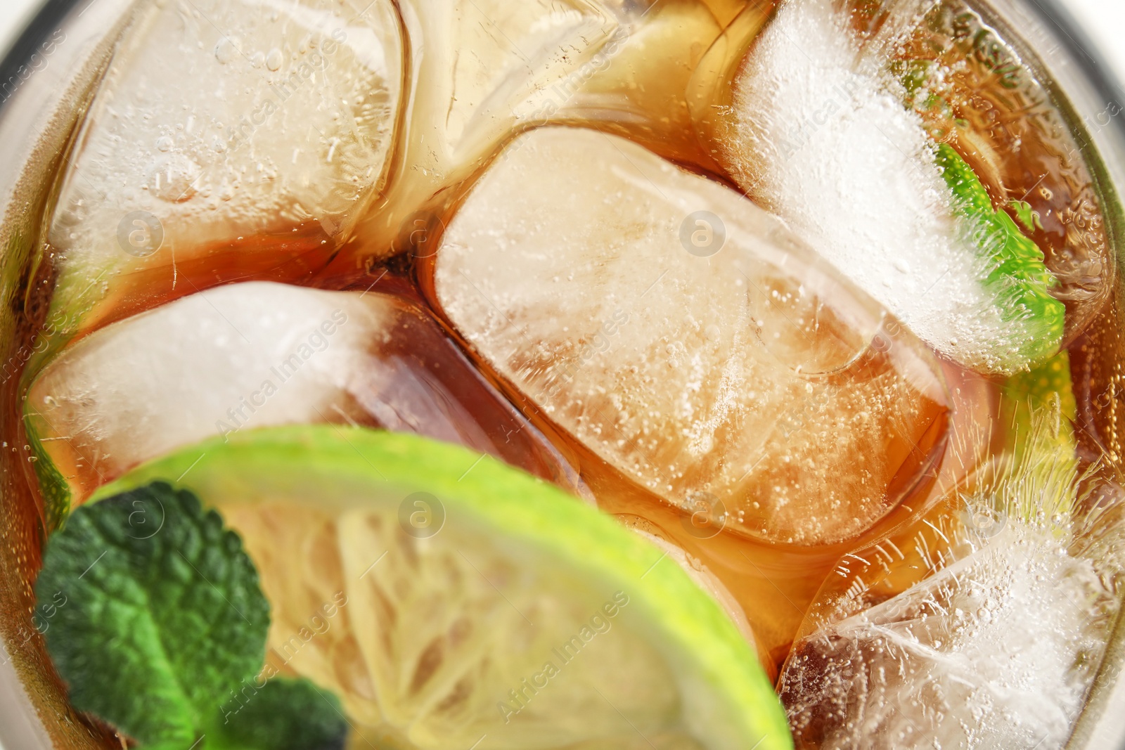 Photo of Refreshing lime drink with ice cubes in glass, top view