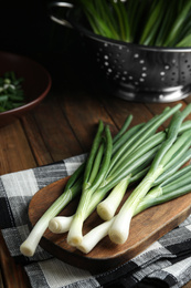 Fresh green spring onions on wooden board