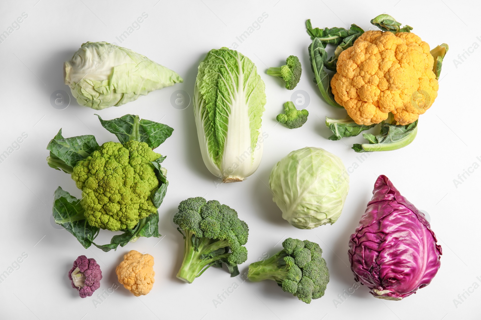 Photo of Different fresh cabbages on white background, top view. Healthy food