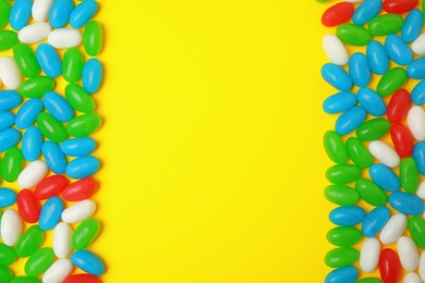 Photo of Frame of jelly beans on color background, top view. Space for text