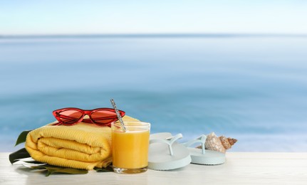 Image of Different beach objects on wooden surface near sea