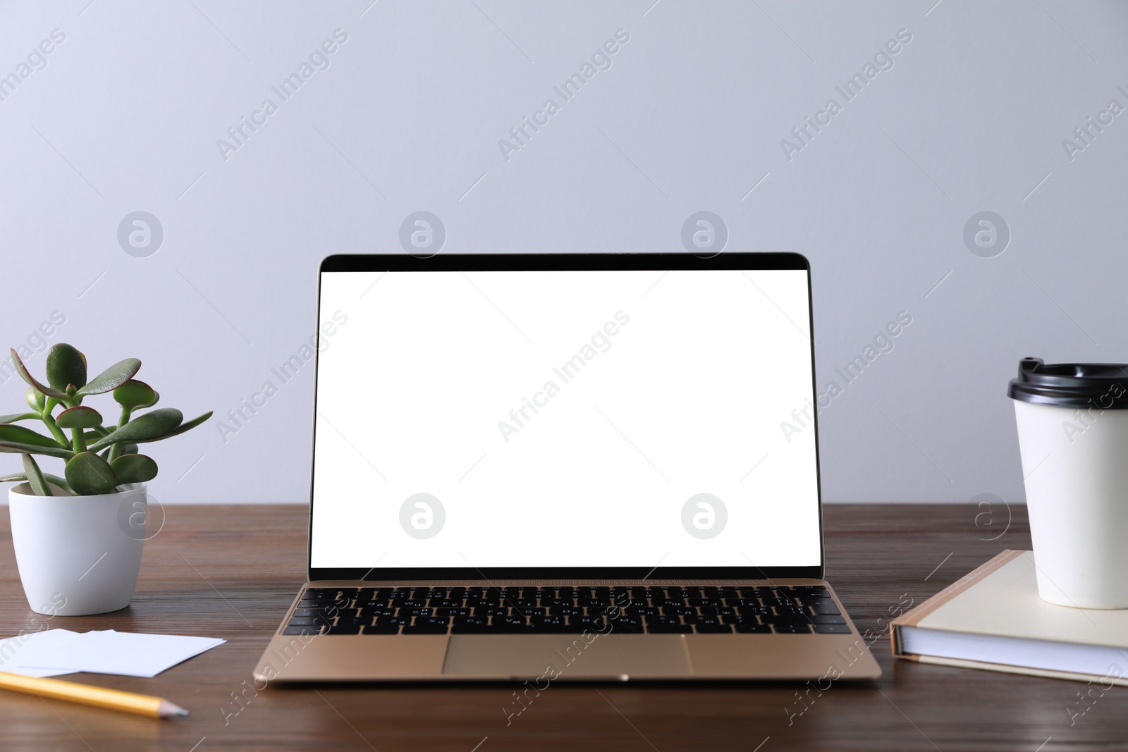 Photo of Workplace with modern laptop on wooden table. Mockup for design