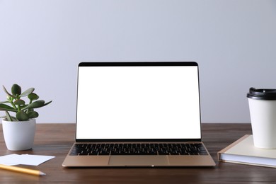 Workplace with modern laptop on wooden table. Mockup for design