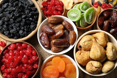 Bowls with different dried fruits on table, top view. Healthy food