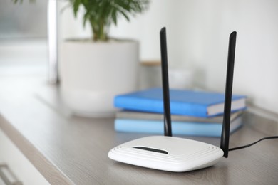 Photo of Modern Wi-Fi router indoors. Space for text