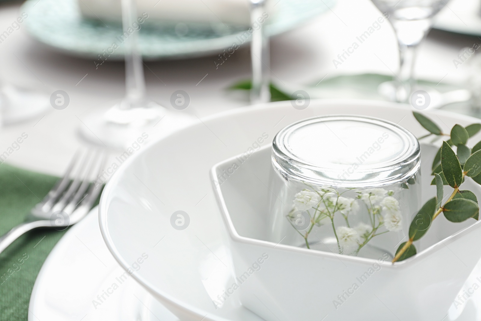 Photo of Stylish tableware with green leaves on table, closeup. Festive setting