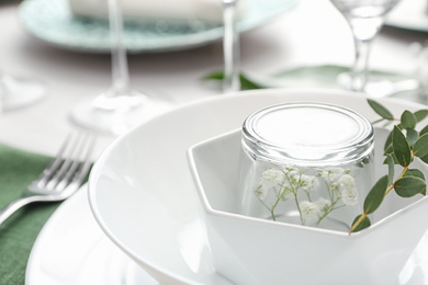 Photo of Stylish tableware with green leaves on table, closeup. Festive setting