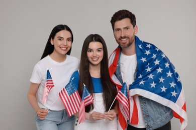 Photo of 4th of July - Independence Day of USA. Happy family with American flags on grey background