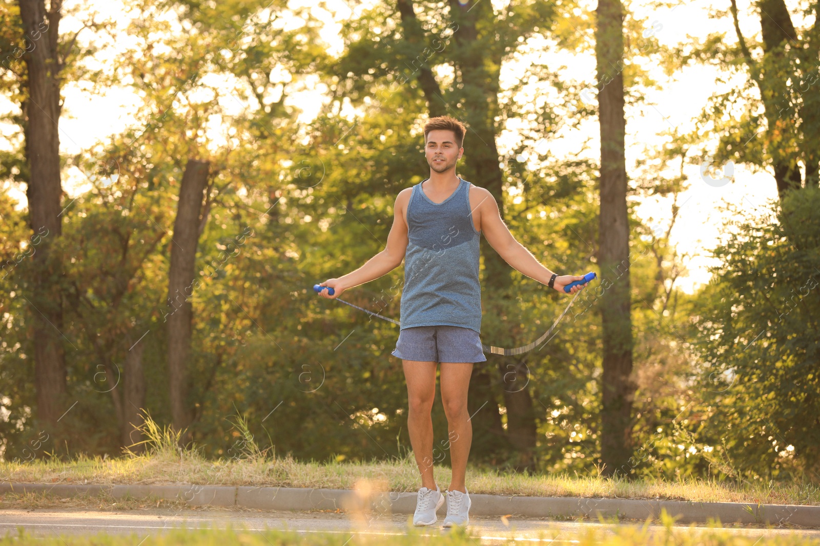 Photo of Young man training with jump rope in park