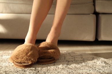 Photo of Woman in fuzzy slippers at home, closeup