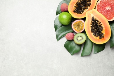 Photo of Fresh ripe papaya and other fruits on light grey table, flat lay. space for text